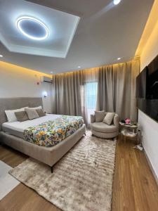 ein Schlafzimmer mit einem Bett, einer Couch und einem Fernseher in der Unterkunft 113 k-chimi in Pointe-Noire