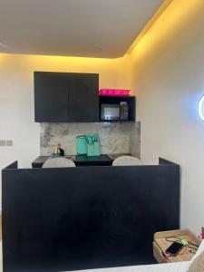 eine Küche mit einer schwarzen Theke mit 2 Stühlen in der Unterkunft 113 k-chimi in Pointe-Noire