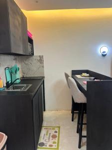 eine Küche mit einer schwarzen Arbeitsplatte und einem Tisch in der Unterkunft 113 k-chimi in Pointe-Noire + 1 Foto