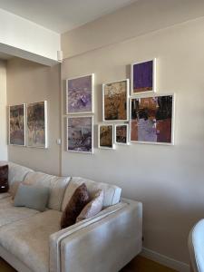 a living room with a couch and paintings on the wall at The Gallery Apartment in Prishtinë
