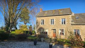 een oud bakstenen huis met een tuin ervoor bij The Lions Den - La Loge Guest House in Mantilly