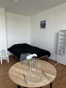 einen Tisch mit Gläsern und Blumen darüber in der Unterkunft Spacieux studio rénové en centre ville - Apt7 in Givet