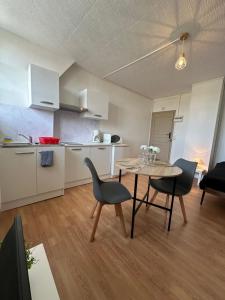 eine Küche und ein Esszimmer mit Tisch und Stühlen in der Unterkunft Spacieux studio rénové en centre ville - Apt7 in Givet