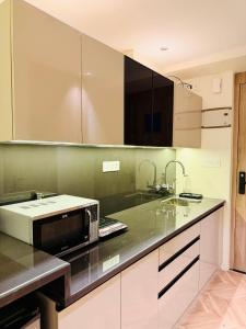 a kitchen with a sink and a microwave on a counter at StayWorks studios in Greater Noida