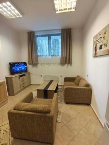 a living room with two couches and a tv at Aparthotel Winslow Highland in Bansko