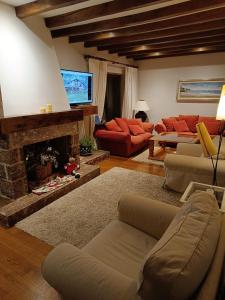 un salon avec un canapé et une cheminée dans l'établissement Casa El Olivo, à Ojedo