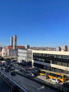 a yellow bus parked in a parking lot in a city at The Gallery Apartment in Prishtinë
