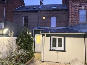 a house with a garage and a brick building at Le cocon avec Terrasse in Amiens