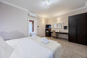 a bedroom with a large white bed and a kitchen at EH Suites Rome Airport Euro House Hotels in Fiumicino +15 photos