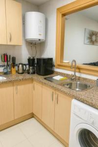 eine Küche mit Spüle und Waschmaschine in der Unterkunft Apartamentos Varadero sea view in La Cala del Moral