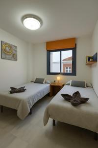 ein Zimmer mit zwei Betten und einem Fenster in der Unterkunft Apartamentos Varadero sea view in La Cala del Moral