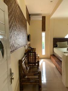 - une chambre avec deux chaises, un lit et une porte dans l'établissement Pondok Elen Mandalika, à Praya