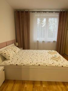 a bed in a bedroom with a window at Apartament Wysoka Brama in Lidzbark Warmiński +14 photos