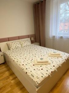 a bedroom with a bed with two towels on it at Apartament Wysoka Brama in Lidzbark Warmiński