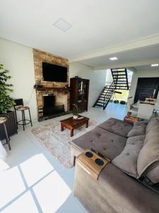 un soggiorno con divano e camino di Casa condomínio lagoa cortada a Balneário Gaivotas Altre 23 foto