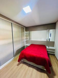 una camera da letto con un letto rosso con una coperta rossa di Casa condomínio lagoa cortada a Balneário Gaivotas