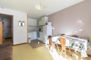 a kitchen and dining room with a table and chairs at Les Orres Plein Sud - Studio avec balcon in Les Orres