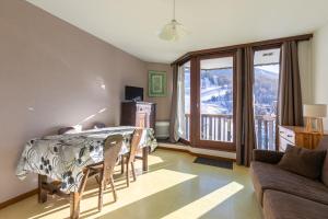 a living room with a table and a balcony at Les Orres Plein Sud - Studio avec balcon in Les Orres