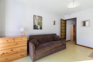 a living room with a couch and a wooden dresser at Les Orres Plein Sud - Studio avec balcon in Les Orres +4 photos