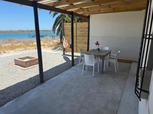 a patio with a table and chairs and the ocean at Bergriver Nest in Velddrif