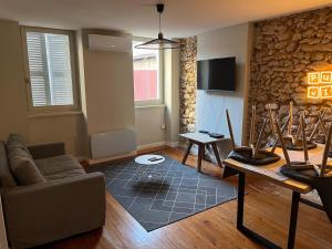 a living room with a couch and a table at Le Cocon Authentique in Mont-de-Marsan