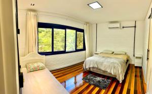 een slaapkamer met een bed en een raam bij Sitio Dona Bela - Rio da Prata in Joinville