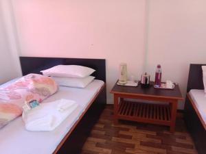 a room with two beds and a nightstand next to a bed sidx sidx sidx at Silverberry Homestay in Rishop