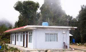 a small white building with a red roof at Silverberry Homestay in Rishop