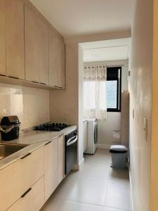 a kitchen with a sink and a stove top oven at Apartamento perto da Praia em Itapema!!! in Itapema