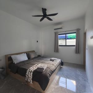 une chambre avec un lit et un ventilateur de plafond dans l'établissement NEW! Naa rak pool villa, à Krabi 26 autres photos