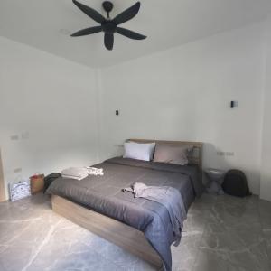 une chambre avec un grand lit avec un ventilateur de plafond dans l'établissement NEW! Naa rak pool villa, à Krabi
