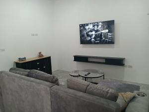 - un salon avec un canapé et une guitare sur le mur dans l'établissement NEW! Naa rak pool villa, à Krabi