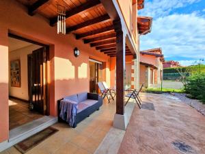 een patio met een bank en stoelen in een huis bij Villa Freya - Casa con jardín cerca de la playa in Las Conchas