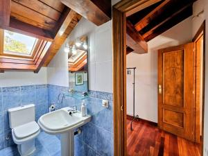een badkamer met een wastafel en een toilet en een raam bij Villa Freya - Casa con jardín cerca de la playa in Las Conchas +41 foto's