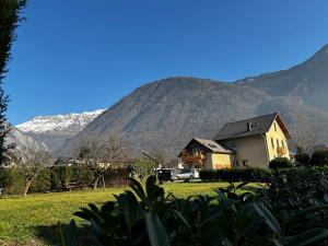 une maison dans un champ avec des montagnes en arrière-plan dans l'établissement L'Augustine - Le Cuchet, à Saint Avre la Chambre