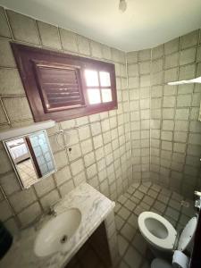 un bagno con lavandino, WC e finestra di Obelisco hotel fazenda a Ubajara