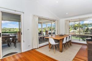 een eetkamer met een tafel, stoelen en ramen bij Neptune's at Manyana in Manyana