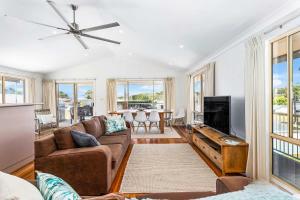 een woonkamer met een bank en een flatscreen-tv bij Neptune's at Manyana in Manyana