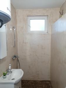 a bathroom with a sink and a window at Апартамент Light blue in Troyan