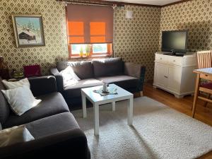 un soggiorno con un divano e un tavolo di Trollhus a Kättilstorp