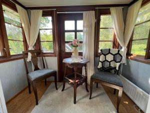 una stanza con due sedie e un tavolo e finestre di Trollhus a Kättilstorp