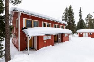a red cabin with snow on the roof at Pyhäkoti B - 30 Meters From the Slopes in Pyhätunturi