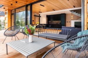 a patio with chairs and a table with a vase of flowers at Zacisze Gór by Apart Concept Podhale in Zakopane