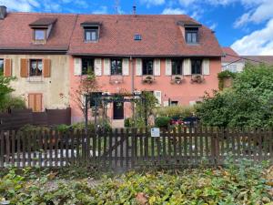 a house with a wooden fence in front of it at Chambre d'hôte chez Hélène in Kaysersberg
