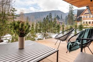 a vase of flowers sitting on a table on a deck at Zacisze Gór by Apart Concept Podhale in Zakopane