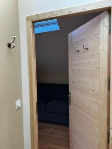 une porte ouverte menant à une chambre avec un canapé bleu dans l'établissement L'Augustine - Le Cuchet, à Saint Avre la Chambre