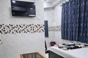 a living room with a tv on a wall at Relax Hotel Kurla in Mumbai +12 photos