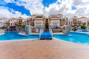 een zwembad met een glijbaan voor een aantal appartementencomplexen bij Yucca Park duplex in Adeje