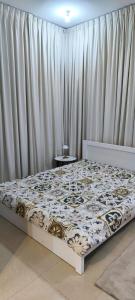 een bed in een kamer met gordijnen en een bed sidx sidx sidx bij Ramco Real Estate LLC in Abu Dhabi