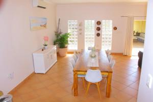 a dining room with a wooden table and chairs at Keke Place in Vila Praia Do Bilene